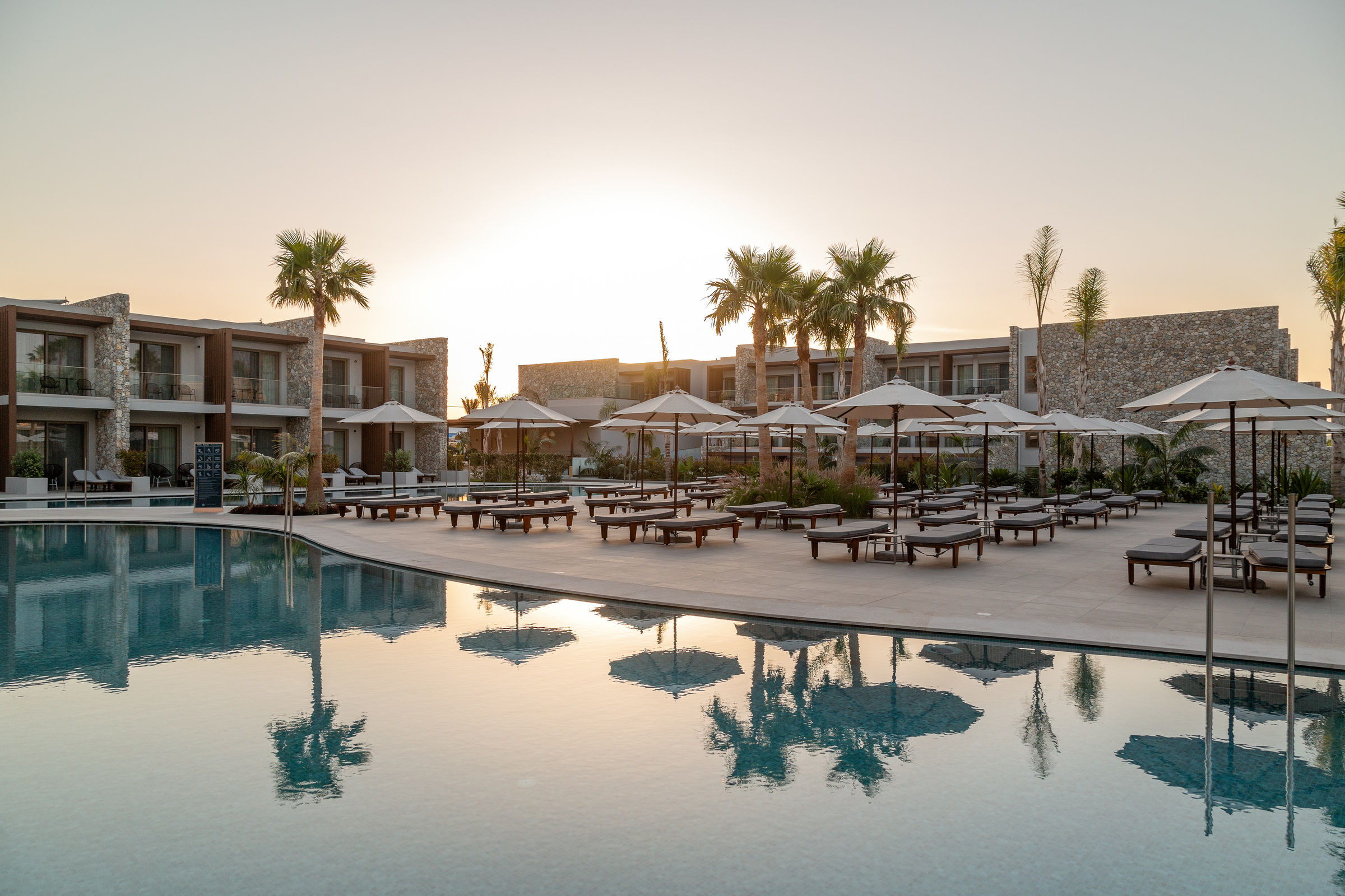 Luxe adults only resort met zwembad en ligbedden bij zonsondergang